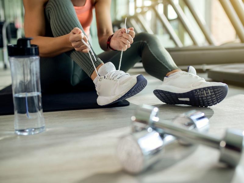 unrecognizable-athletic-woman-tying-sports-shoe-health-club.jpg